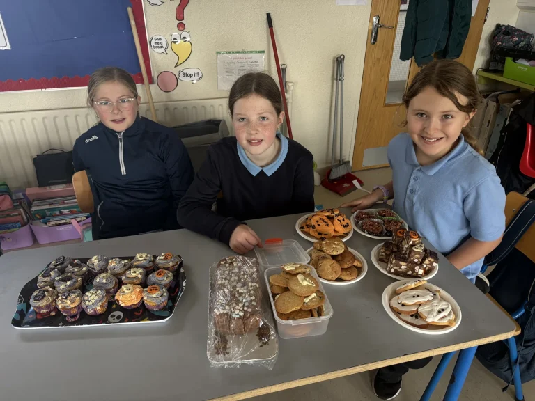 Pupils with a table of homemade treats at Bun and Biscuit Day